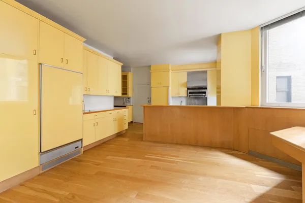 a large white kitchen with wooden floor