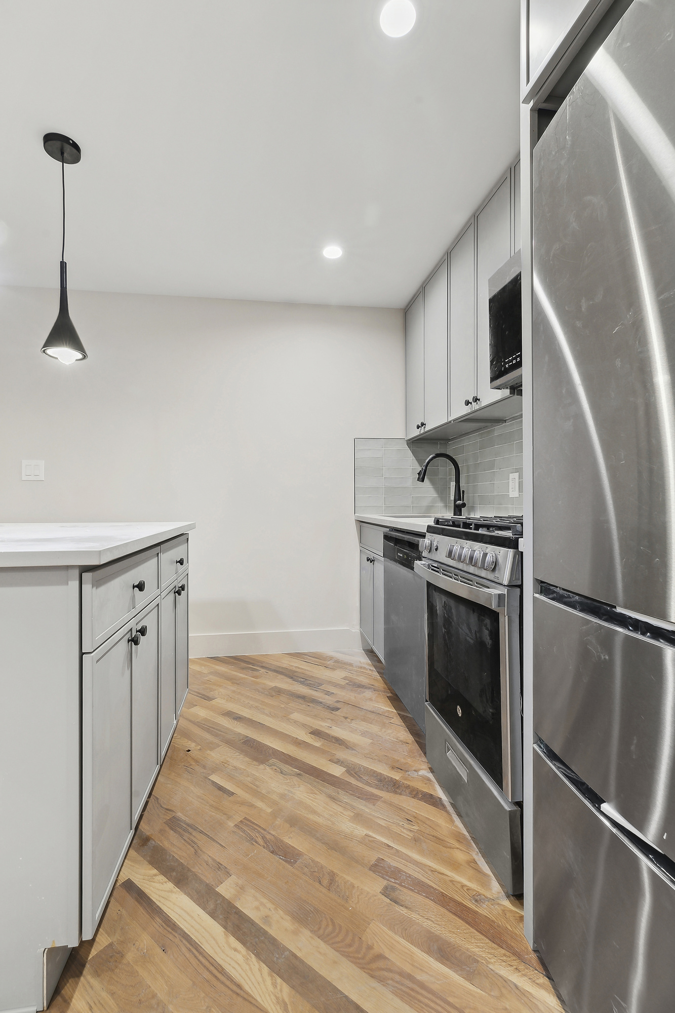 1265 Madison Street, Unit 1 Brooklyn, NY 11221 - Photo 4 of 11 a kitchen with stainless steel appliances granite countertop a refrigerator sink and stove