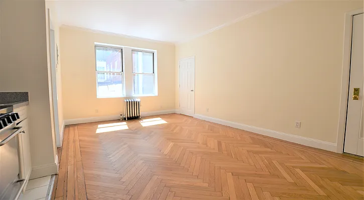 117 West 13th Street, Unit 25 Manhattan, NY 10011 - Photo 1 of 7 a view of empty room with wooden floor and fan