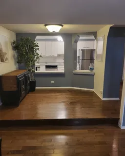 a view of empty room with wooden floor and a fireplace