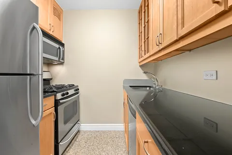 a kitchen with stainless steel appliances granite countertop a refrigerator and a stove top oven