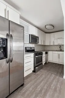 a kitchen with granite countertop a refrigerator and a sink