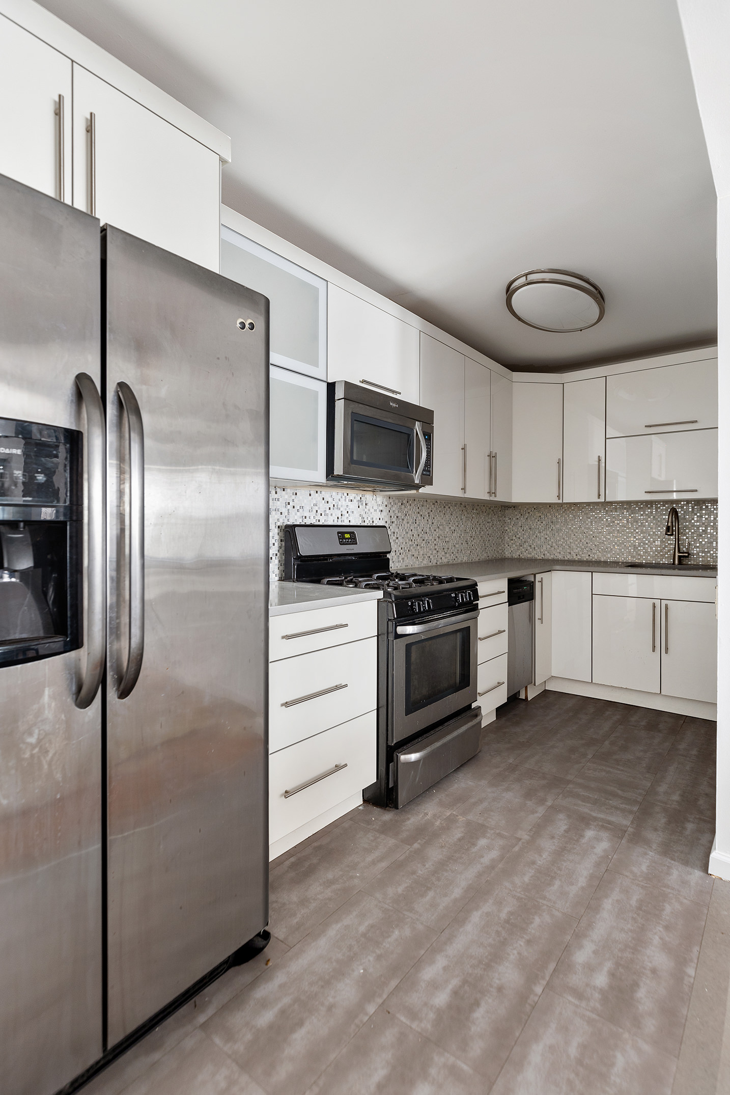 246 Sumpter Street, Unit 1C Brooklyn, NY 11233 - Photo 7 of 12 a kitchen with granite countertop a refrigerator and a sink
