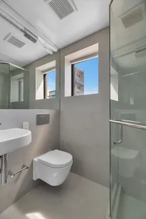 a bathroom with a toilet a sink and mirror