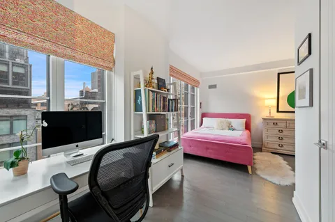 a bedroom with furniture and a flat screen tv