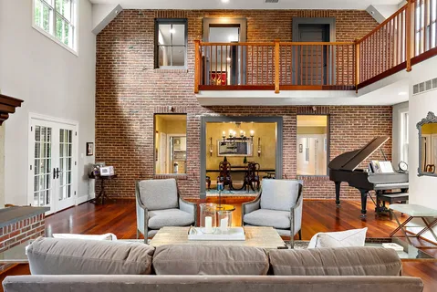 a living room with furniture a fireplace and a large window