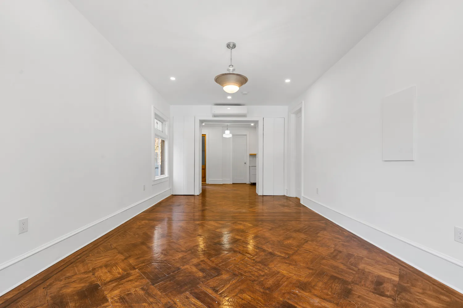 a view of an empty room with wooden floor