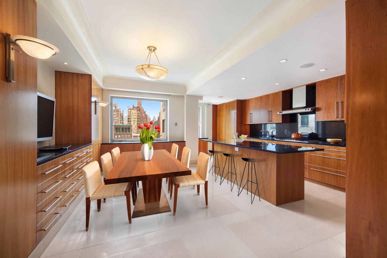 923 5th Avenue, Unit 15A Manhattan, NY 10021 - Photo 2 of 10 a kitchen with stainless steel appliances granite countertop a stove top oven a sink a dining table and chairs with wooden floor