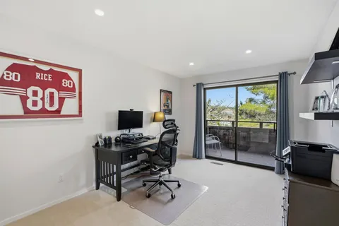 a view of a workspace with furniture and a window