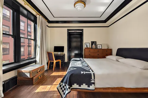 a bedroom with bed and wooden floor