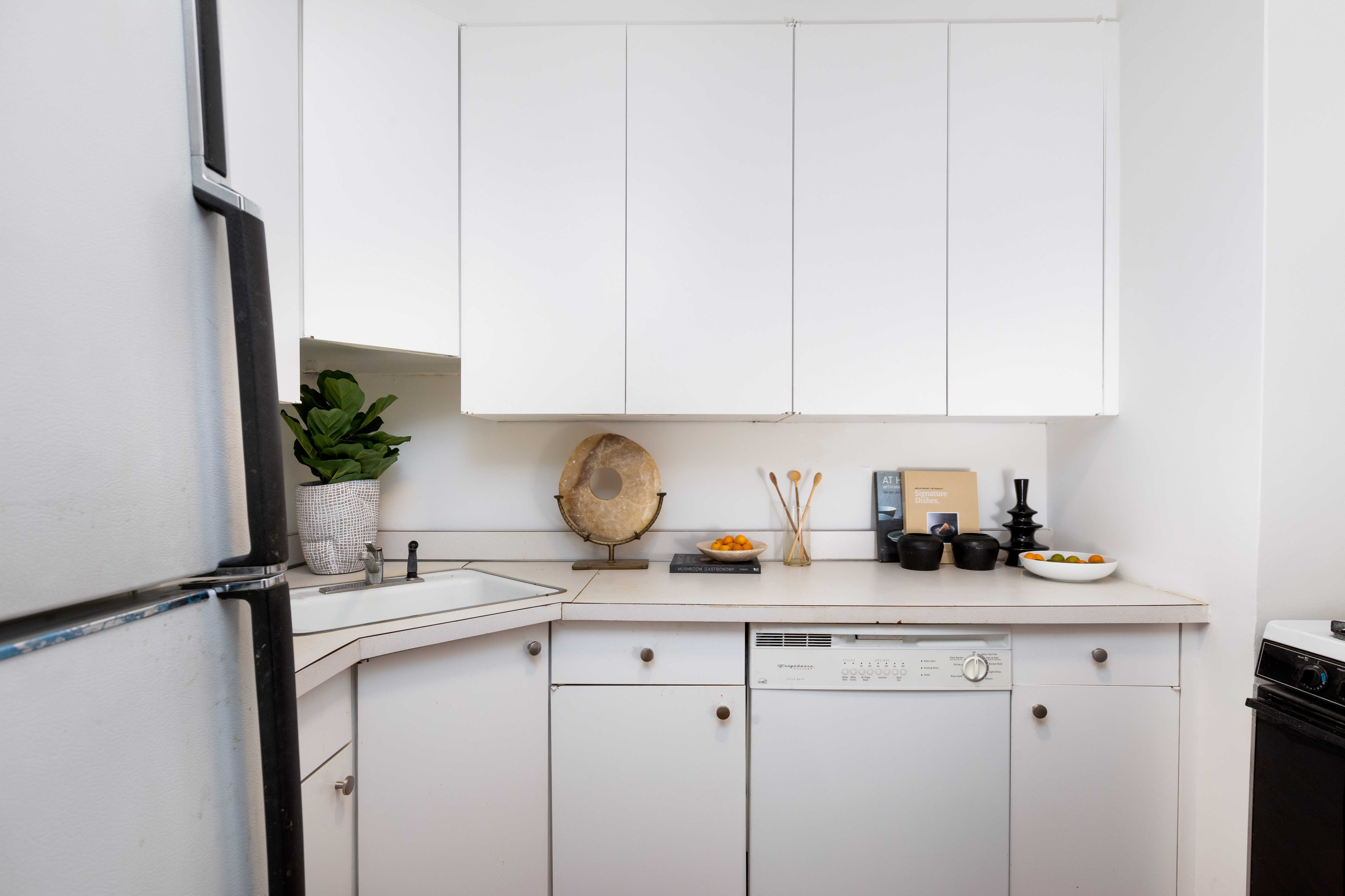 80 Central Park West, Unit 12C Manhattan, NY 10023 - Photo 16 of 27 a kitchen with stainless steel appliances granite countertop white cabinets and a refrigerator