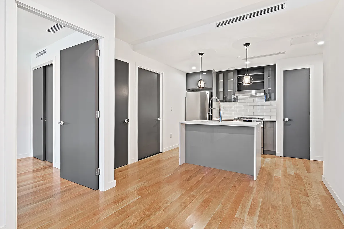 41-21 23rd Street, Unit 6C Queens, NY 11101 - Photo 3 of 10 a kitchen with stainless steel appliances granite countertop a refrigerator and a sink