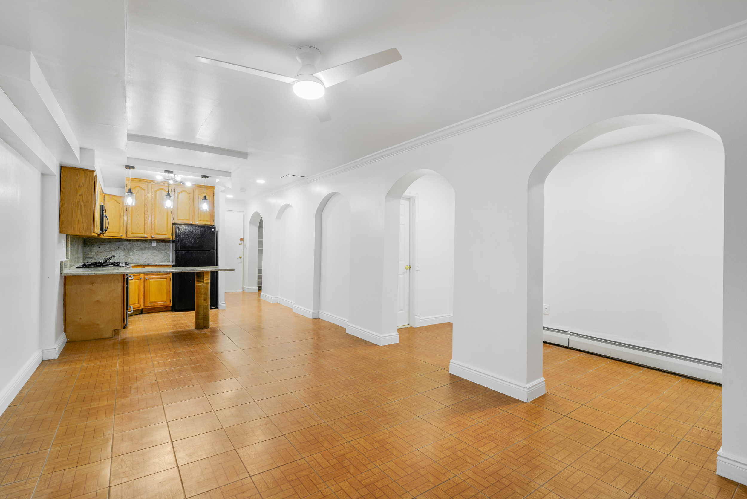 3 East 128th Street, Unit GARDEN Manhattan, NY 10035 - Photo 2 of 10 a view of an empty room with kitchen and a window