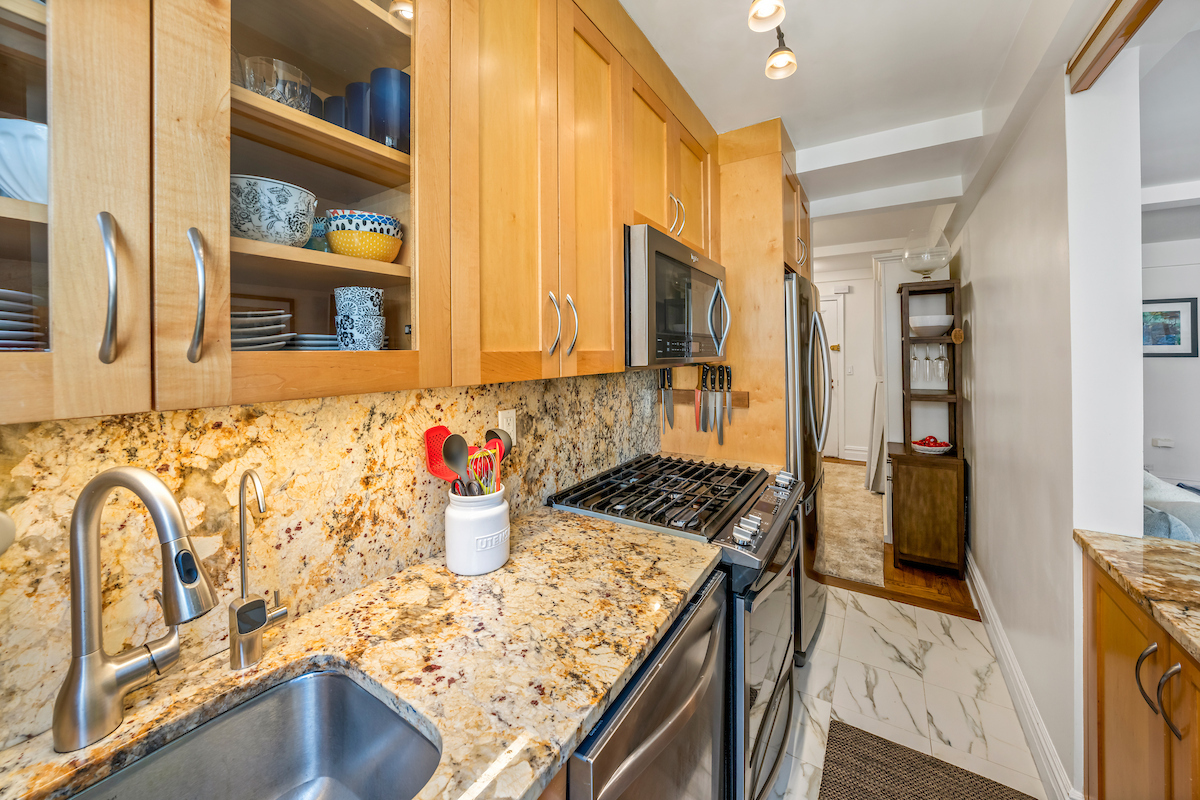 424 East 52nd Street, Unit 9B Manhattan, NY 10022 - Photo 4 of 9 a kitchen with a stove a sink and a refrigerator