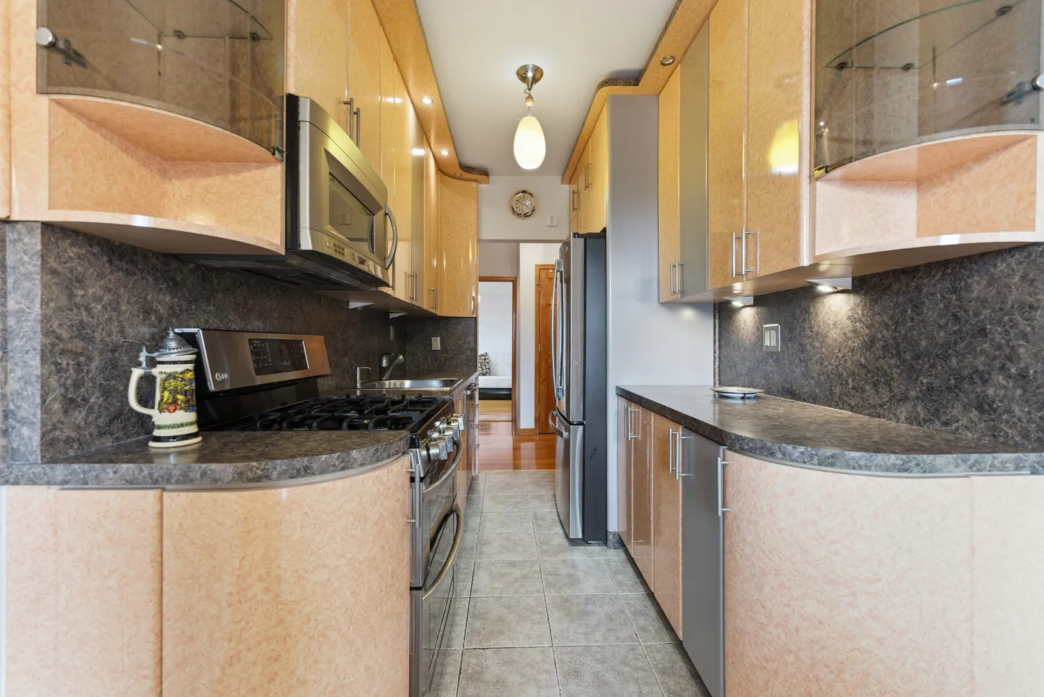 a kitchen with stainless steel appliances granite countertop a sink a stove and a refrigerator