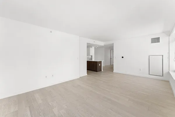 a view of an empty room with a kitchen