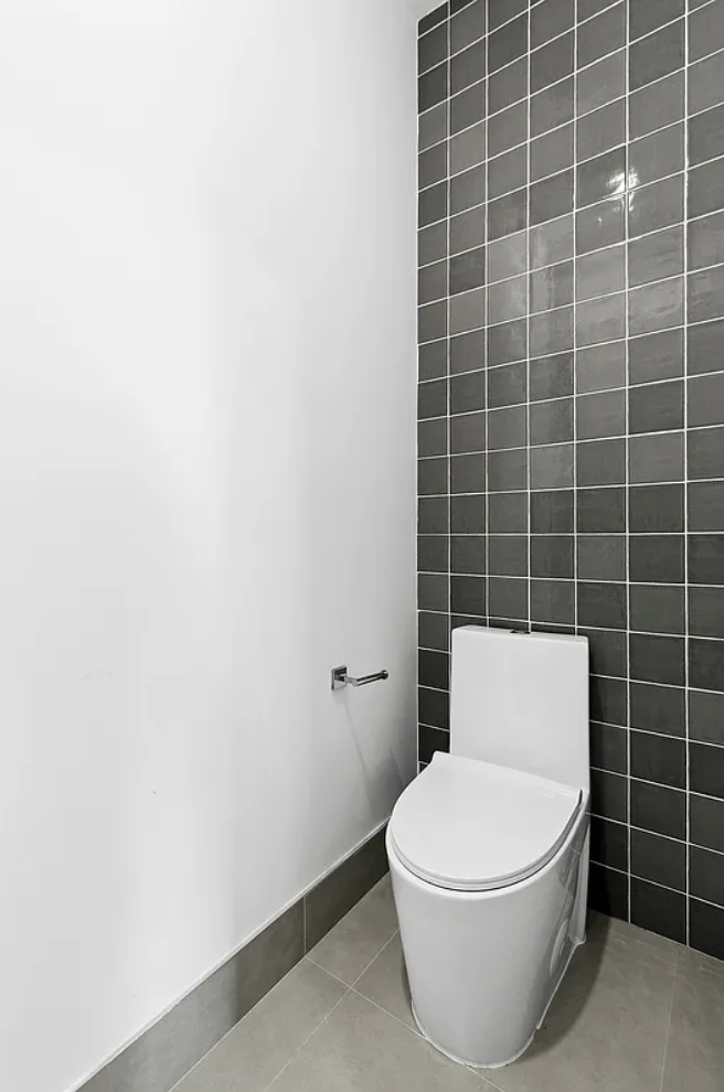 138 Schaefer Street, Unit 3 Brooklyn, NY 11207 - Photo 10 of 11 a white toilet sitting next to a bathroom sink