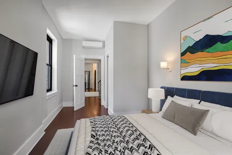 a bedroom with a bed and a flat screen tv