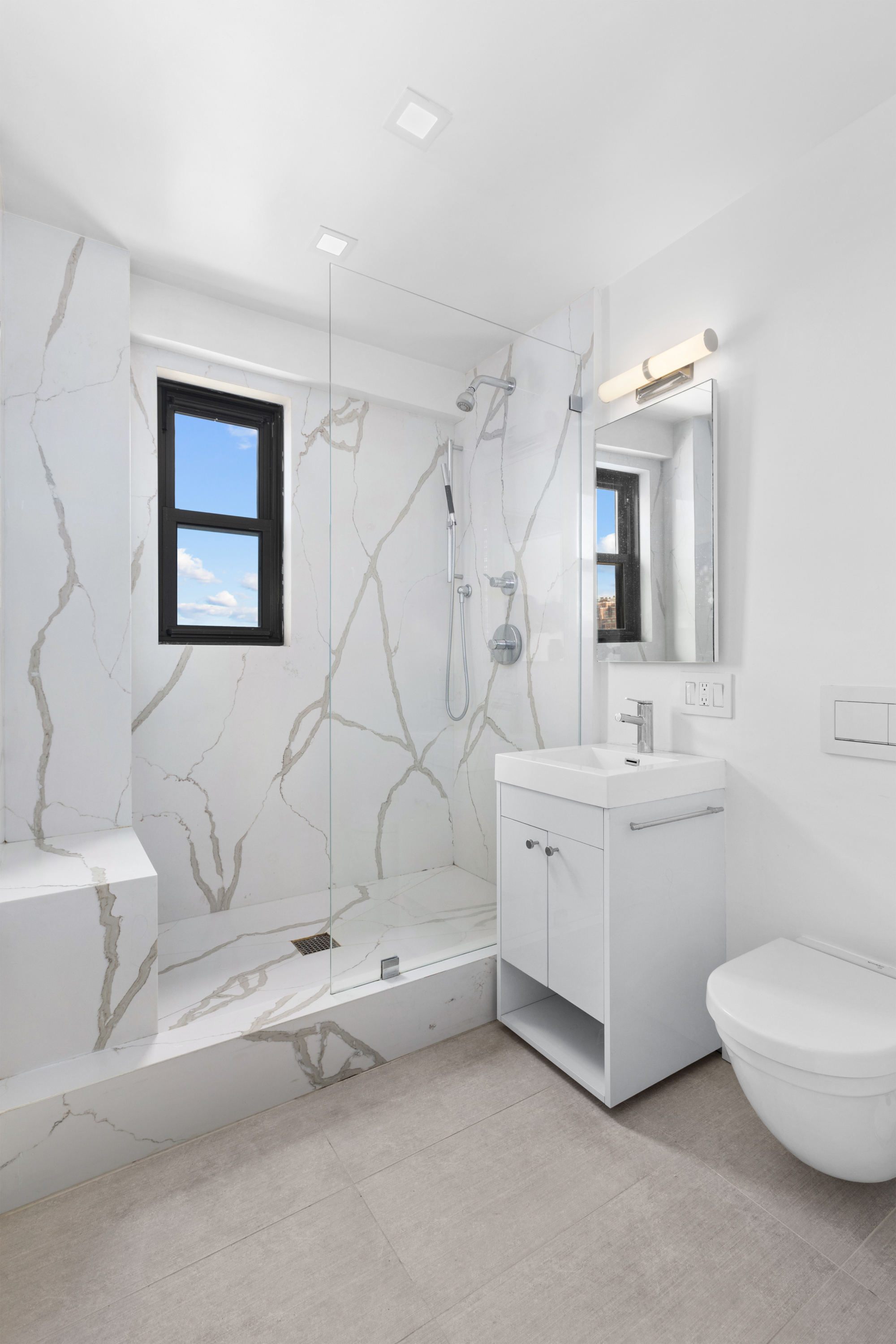 201 West 21st Street, Unit 15J Manhattan, NY 10011 - Photo 5 of 6 a bathroom with a granite countertop sink mirror and toilet