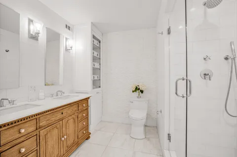 a spacious bathroom with a granite countertop sink a toilet and a shower