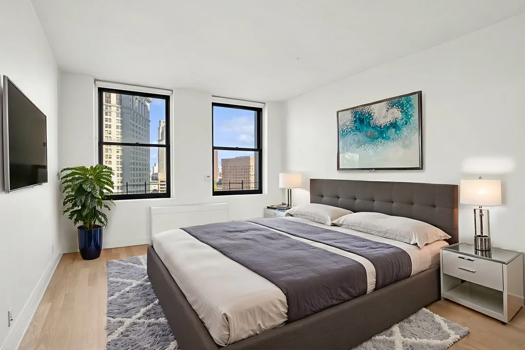 a bedroom with a large bed and a potted plant