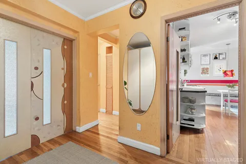 a view of a hallway with wooden floor and entryway
