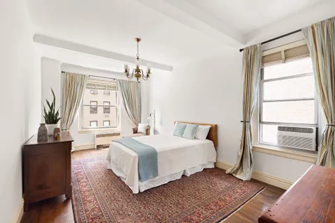 a bedroom with a large bed and a chandelier