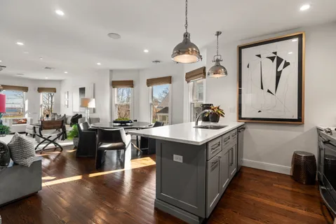 a kitchen with stainless steel appliances granite countertop a stove and a wooden floors
