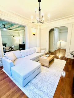 a living room with couch and a chandelier