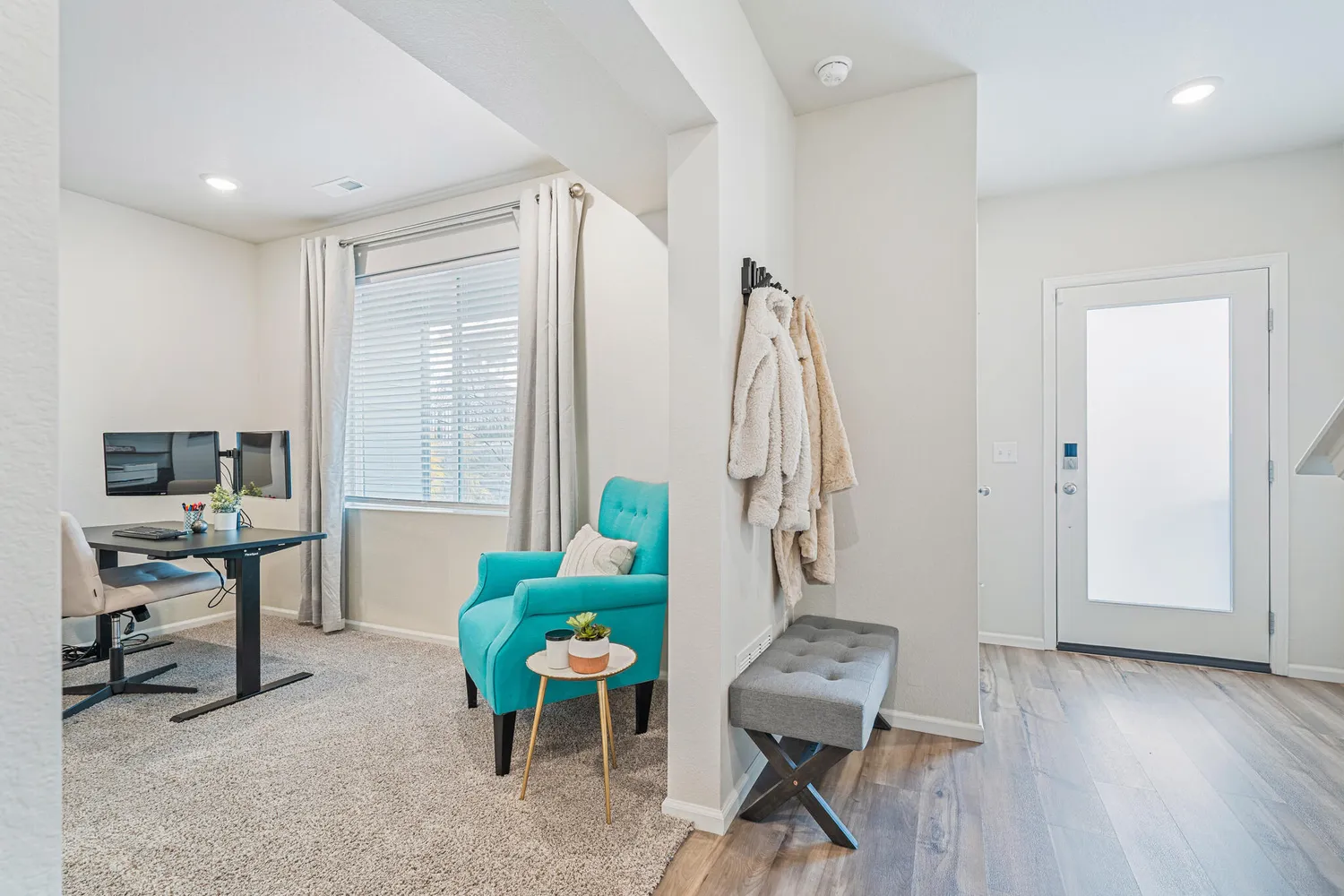 a view of a workspace with furniture and a window