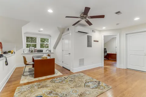 a view of a livingroom with wooden floor and a ceiling fan