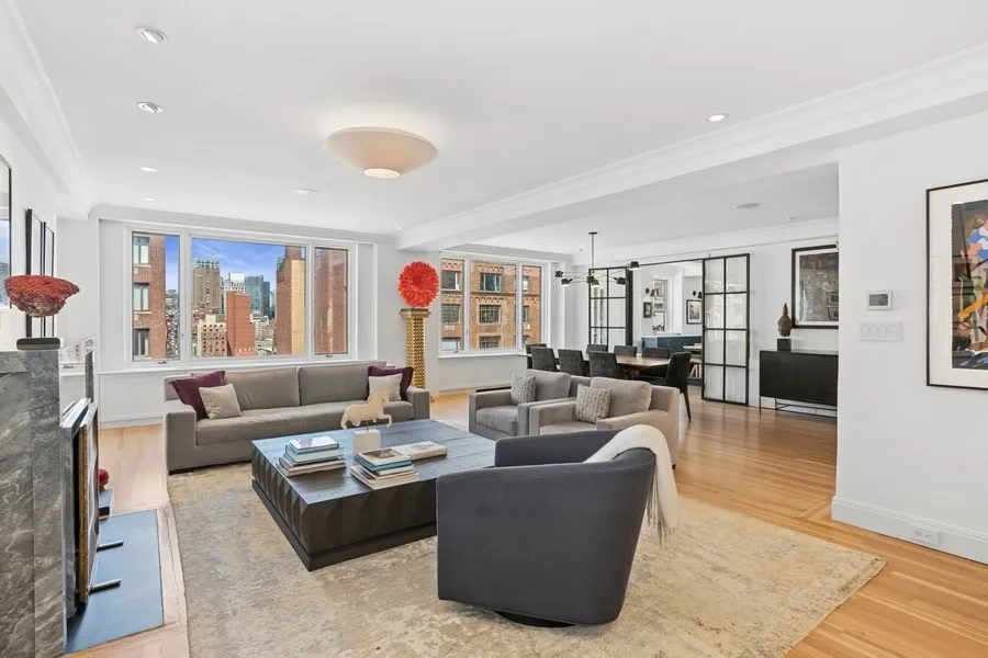 a living room with furniture kitchen view and a window