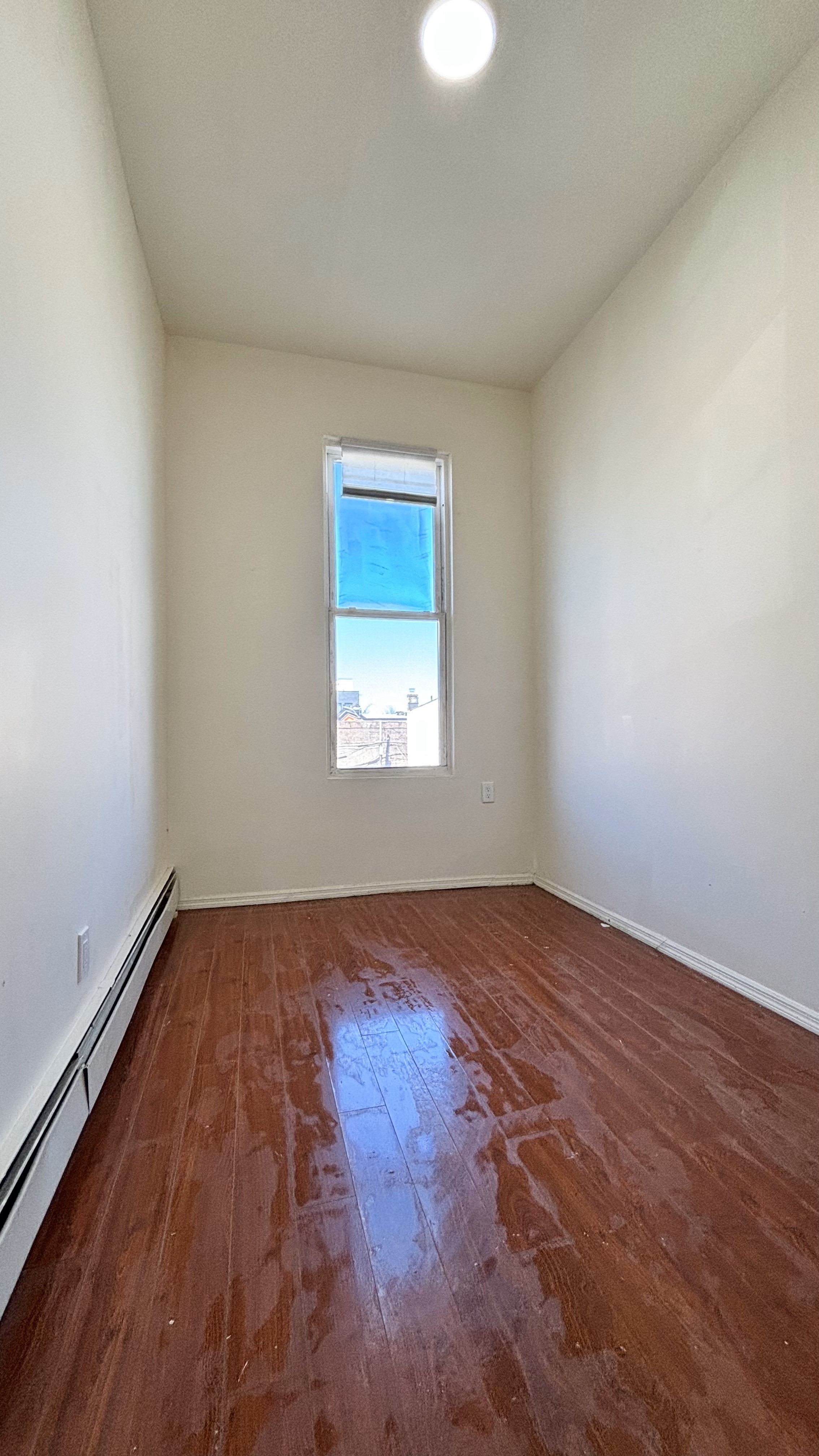 74 Himrod Street, Unit 2 Brooklyn, NY 11221 - Photo 12 of 16 an empty room with wooden floor and windows
