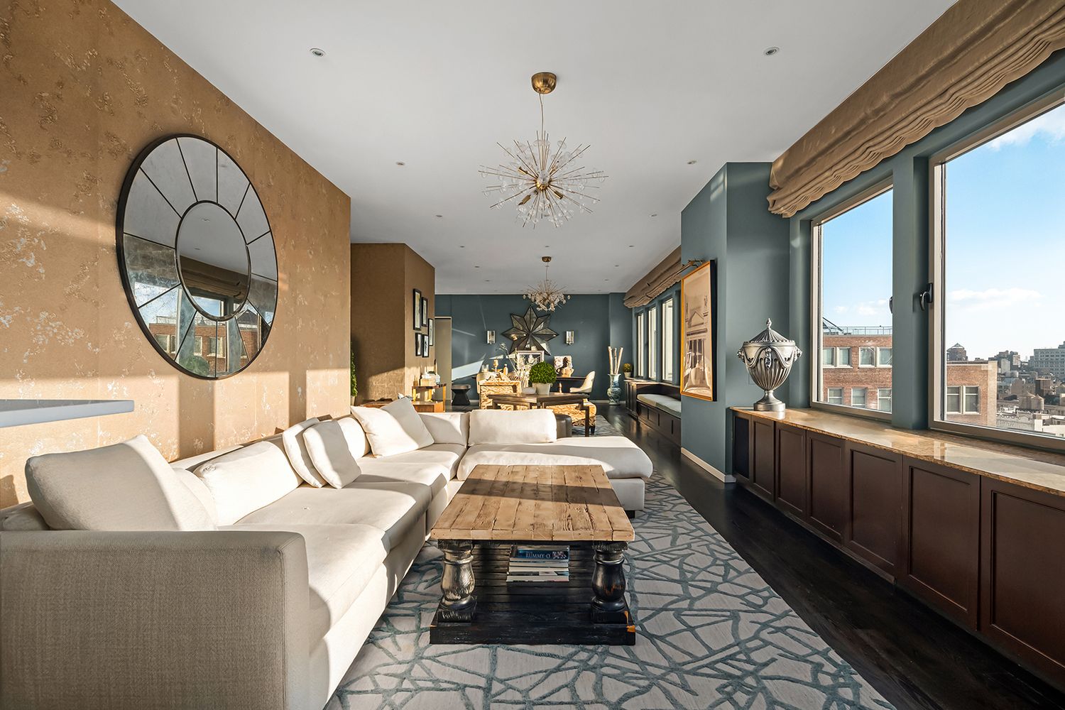 a living room with furniture a mirror and a large window