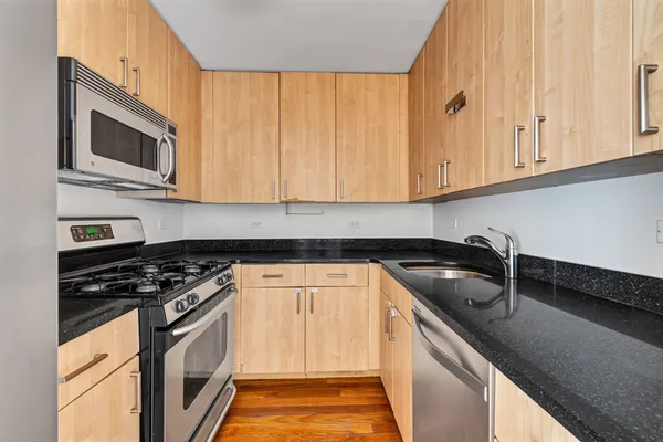 a kitchen with stainless steel appliances granite countertop a sink and a stove