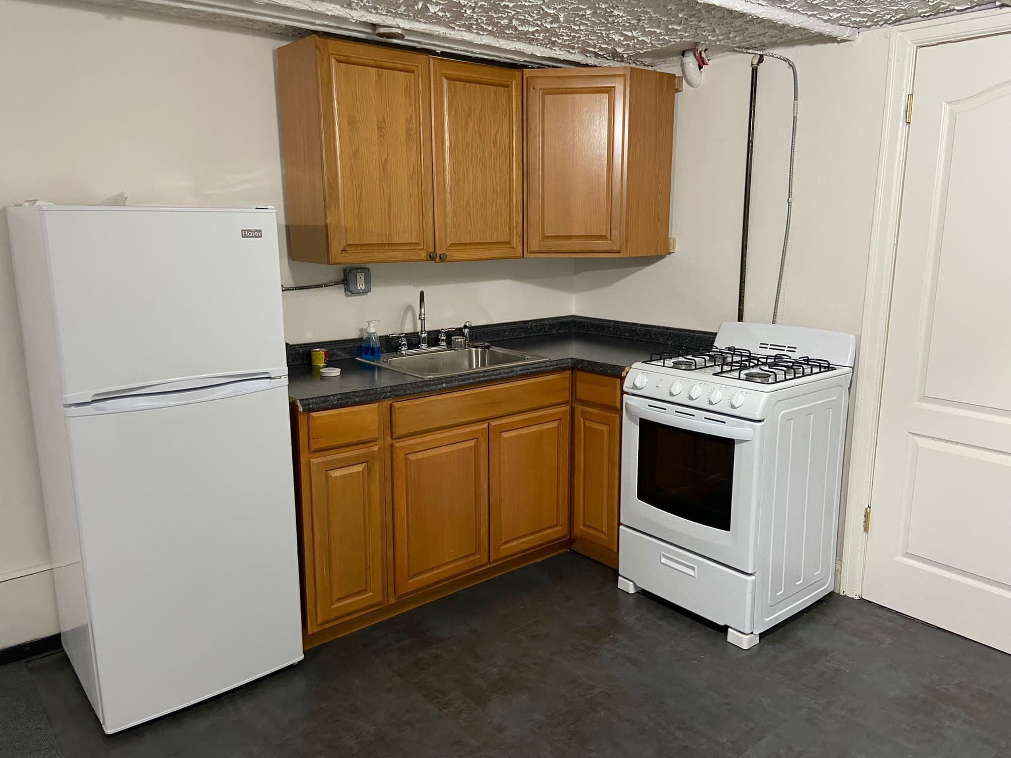 1065 East 39th Street Brooklyn, NY 11210 - Photo 11 of 15 a kitchen with stainless steel appliances granite countertop a stove a refrigerator and a sink