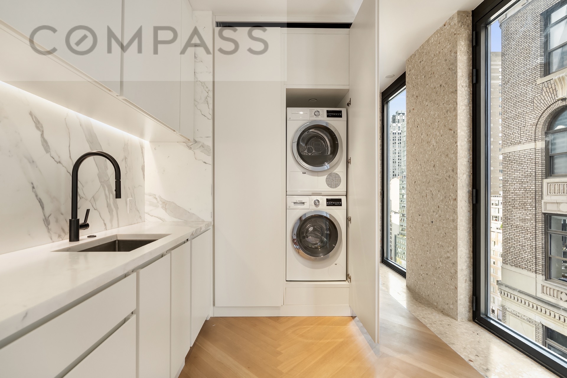 16 West 40th Street, Unit 21B Manhattan, NY 10018 - Photo 13 of 18 a kitchen with a sink and a washer dryer