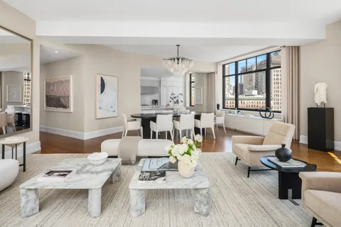 a living room with furniture dining table wooden floor and a large window