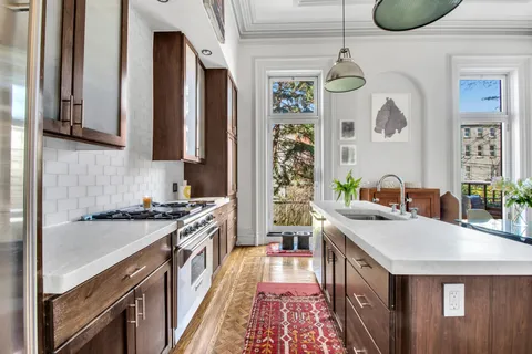 a kitchen with stainless steel appliances granite countertop a stove a sink and a refrigerator