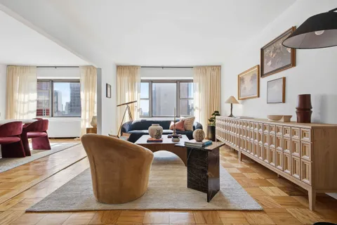 a living room with furniture windows and a wooden floor