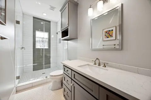 a bathroom with a sink a toilet and shower