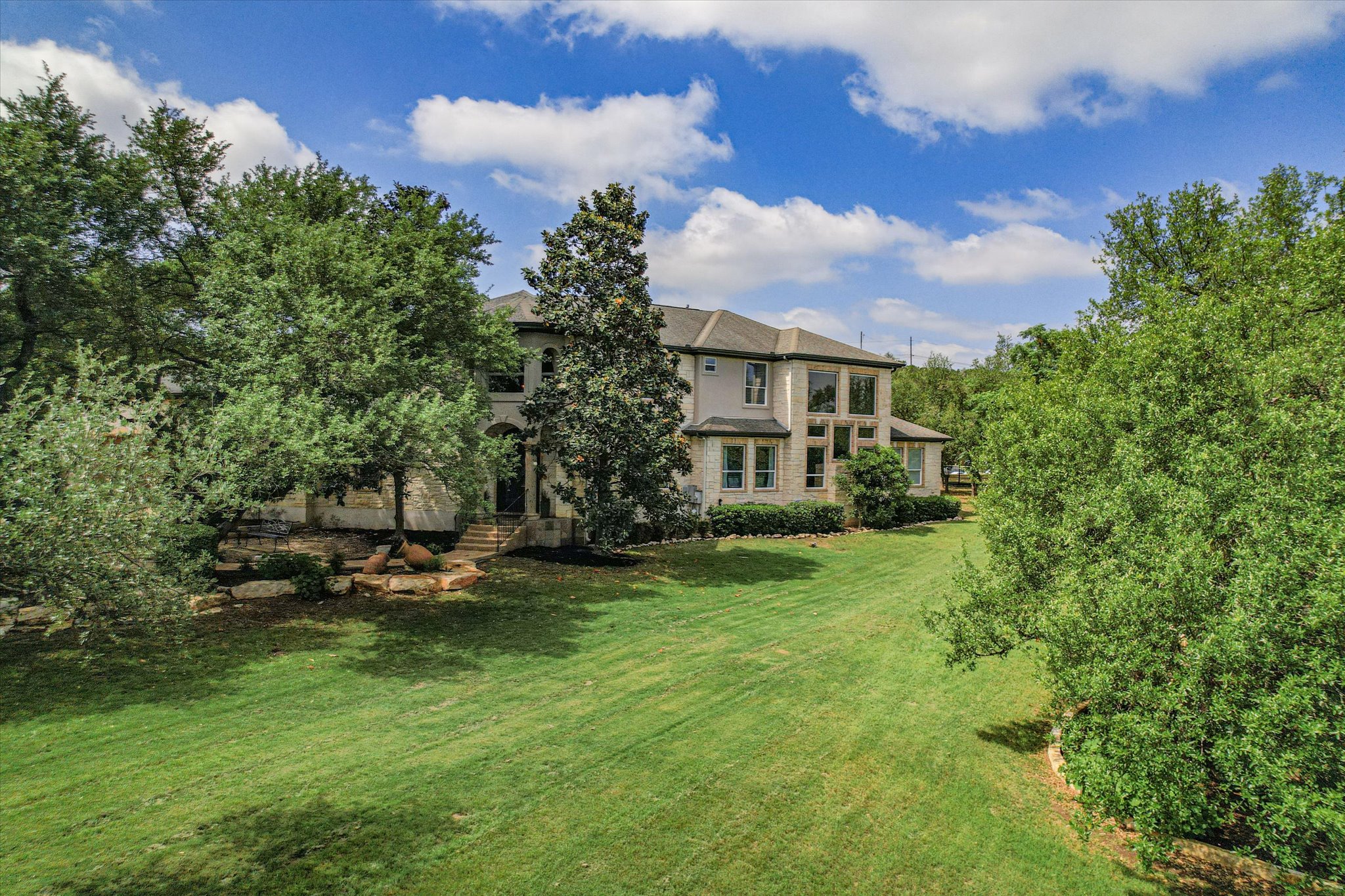 1422 Palomino Ridge Drive Austin, TX 78733 - Photo 2 of 60 a view of a house with a garden and trees