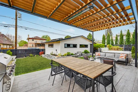 a patio with a table and chairs and potted plants