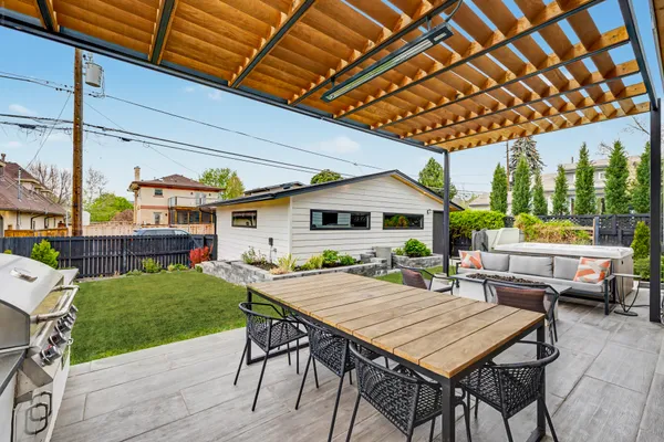 a patio with a table and chairs and potted plants