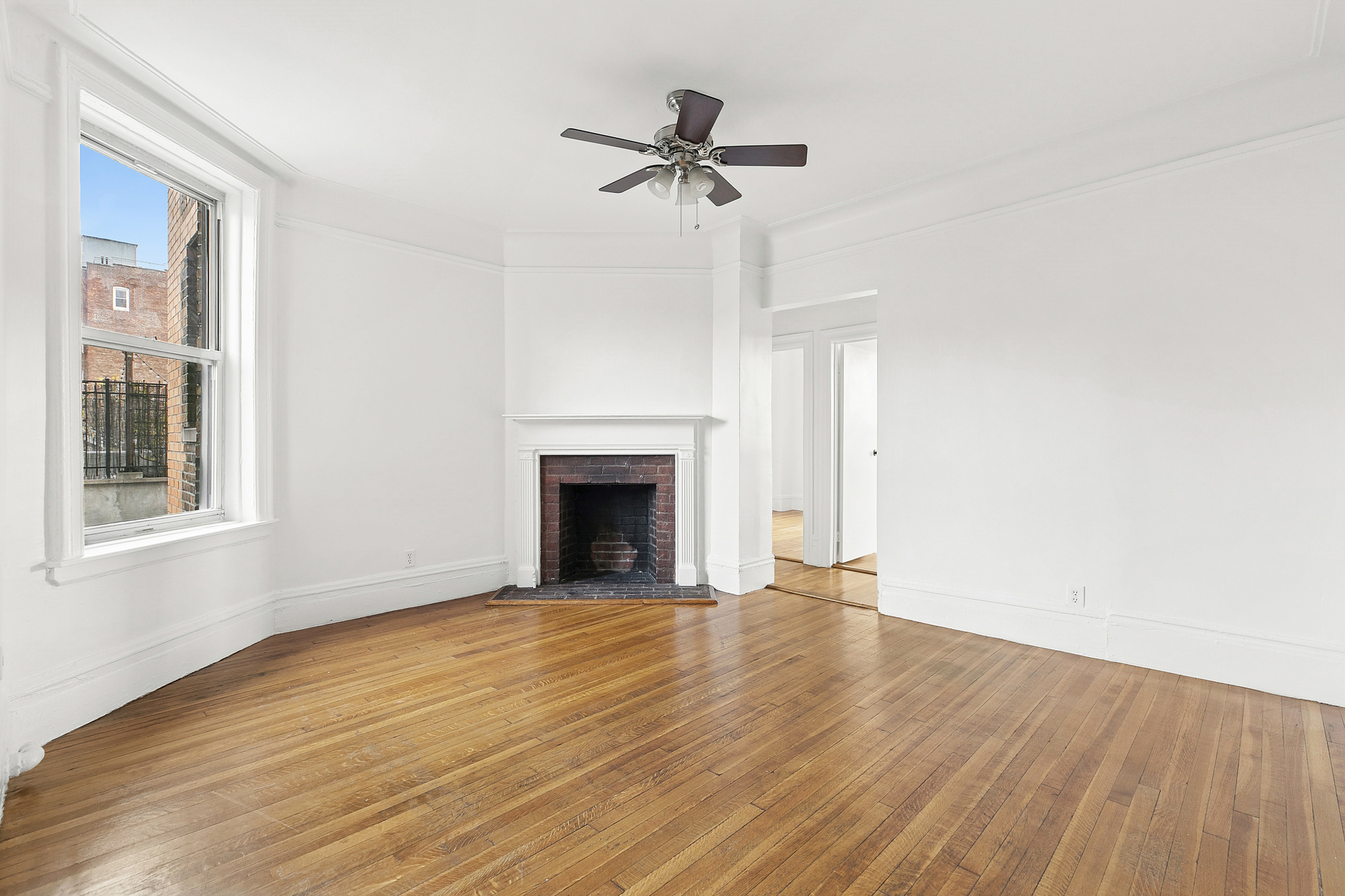 a view of empty room with wooden floor and fireplace