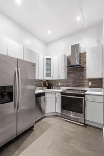 a kitchen with stainless steel appliances granite countertop a stove a sink and a refrigerator