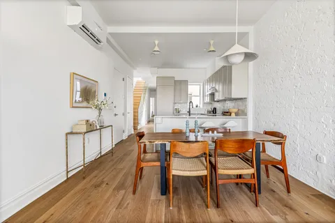 a dining room with stainless steel appliances kitchen island a table and chairs in it