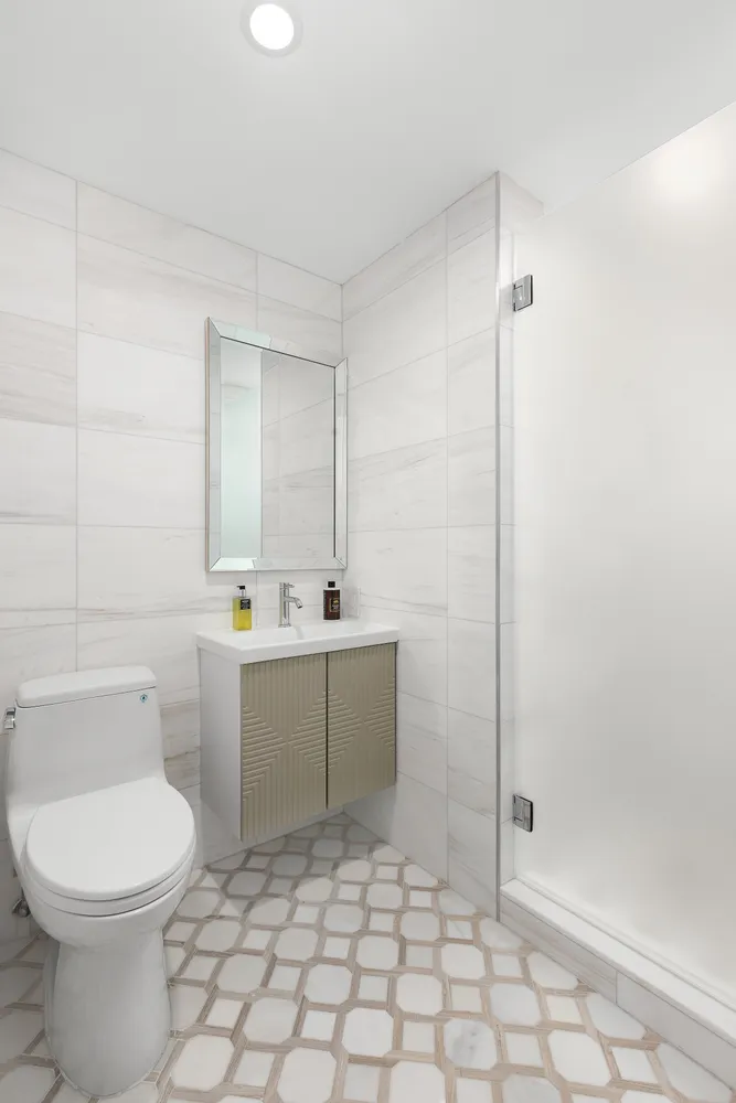 a bathroom with a sink a toilet and shower