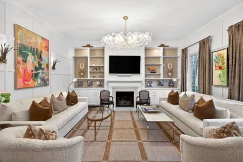 a living room with furniture a fireplace and a flat screen tv