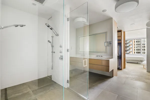 a bathroom with a tub shower sink and mirror